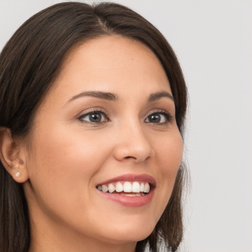 Joyful white young-adult female with long  brown hair and brown eyes