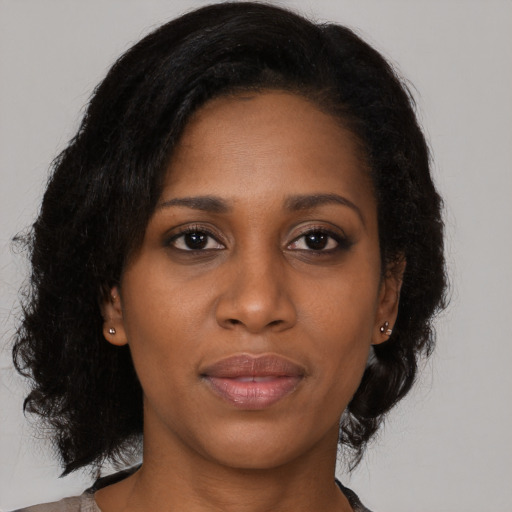 Joyful black young-adult female with medium  black hair and brown eyes