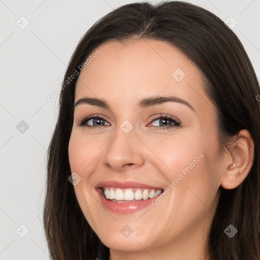 Joyful white young-adult female with long  brown hair and brown eyes