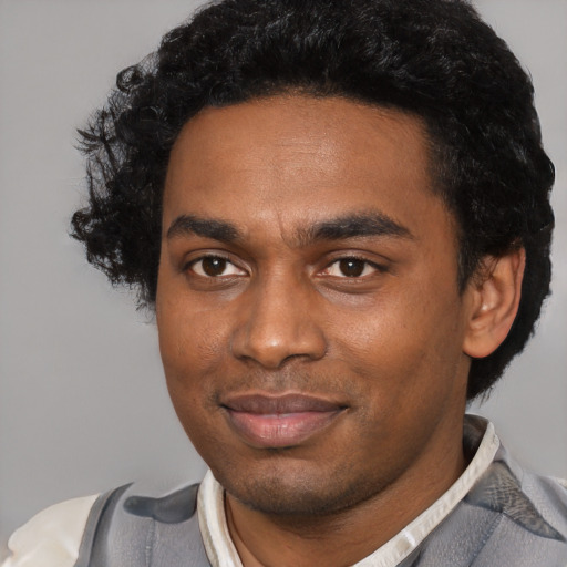 Joyful black young-adult male with short  black hair and brown eyes