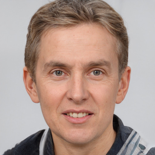 Joyful white adult male with short  brown hair and grey eyes