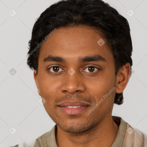 Joyful black young-adult male with short  black hair and brown eyes