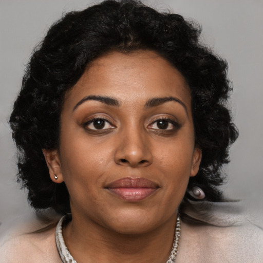 Joyful black young-adult female with long  brown hair and brown eyes