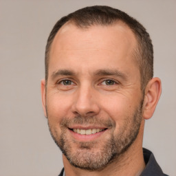 Joyful white adult male with short  brown hair and brown eyes