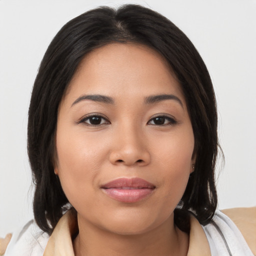 Joyful latino young-adult female with medium  brown hair and brown eyes