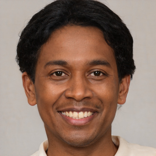 Joyful latino young-adult male with short  brown hair and brown eyes