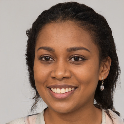 Joyful black young-adult female with short  brown hair and brown eyes