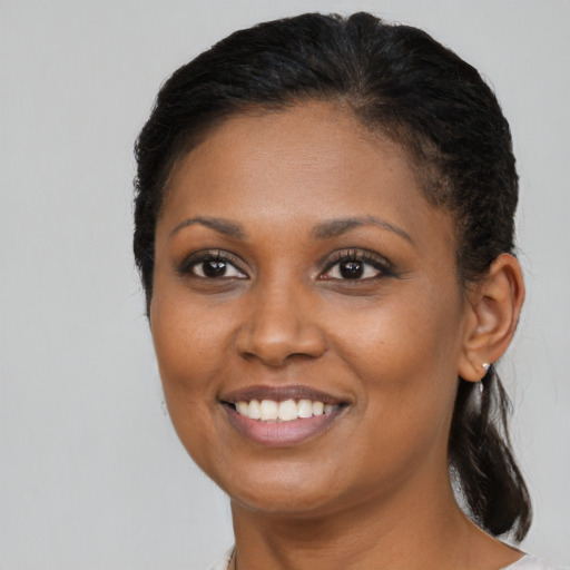 Joyful black young-adult female with medium  brown hair and brown eyes
