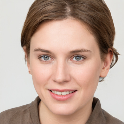 Joyful white young-adult female with short  brown hair and grey eyes