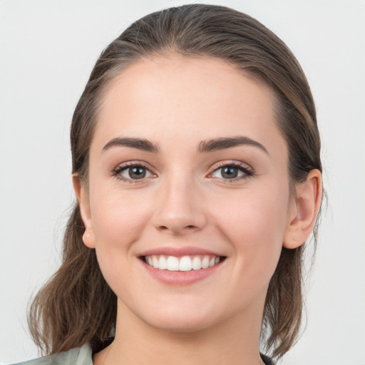 Joyful white young-adult female with medium  brown hair and grey eyes