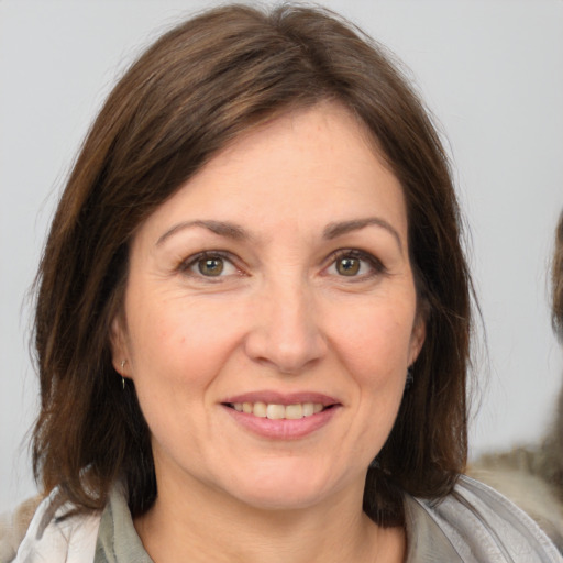 Joyful white adult female with medium  brown hair and brown eyes