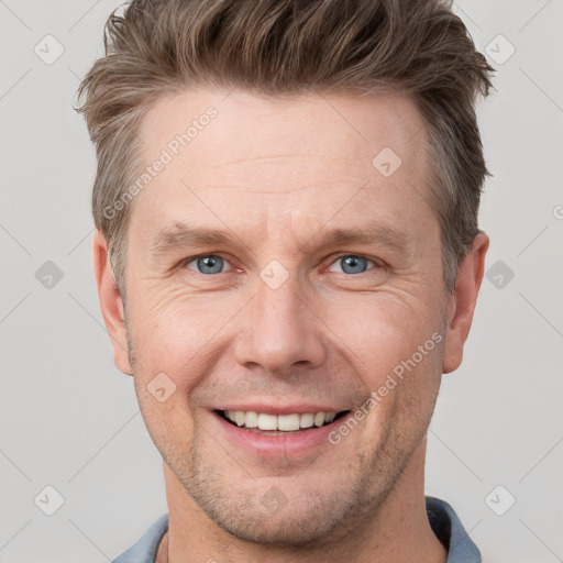 Joyful white adult male with short  brown hair and grey eyes