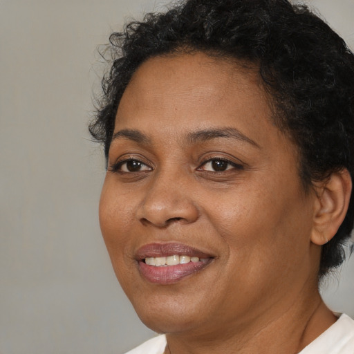Joyful black adult female with short  brown hair and brown eyes
