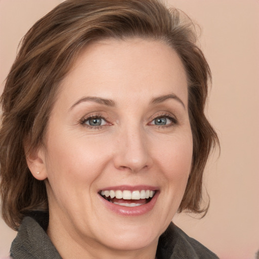 Joyful white adult female with medium  brown hair and grey eyes