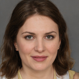 Joyful white young-adult female with medium  brown hair and green eyes