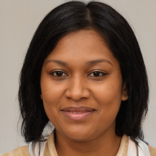 Joyful black young-adult female with medium  brown hair and brown eyes