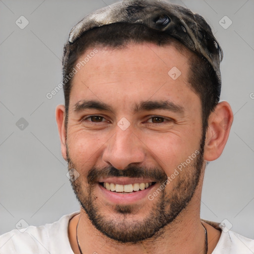 Joyful white young-adult male with short  black hair and brown eyes