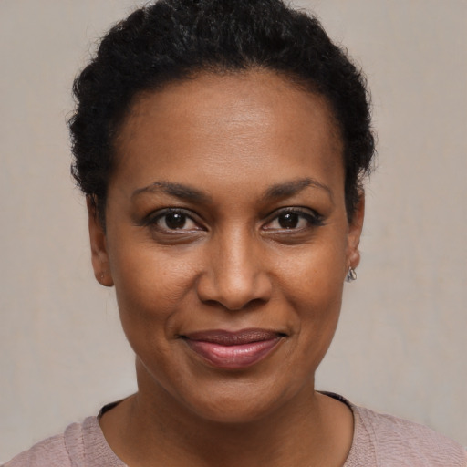 Joyful black young-adult female with short  black hair and brown eyes