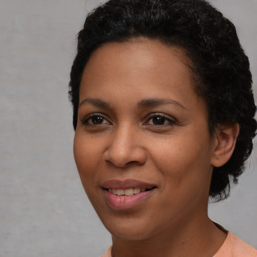 Joyful latino young-adult female with short  black hair and brown eyes