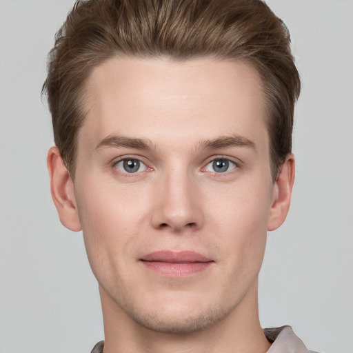 Joyful white young-adult male with short  brown hair and grey eyes