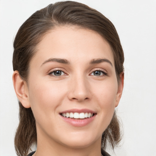 Joyful white young-adult female with medium  brown hair and grey eyes