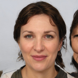 Joyful white adult female with medium  brown hair and grey eyes