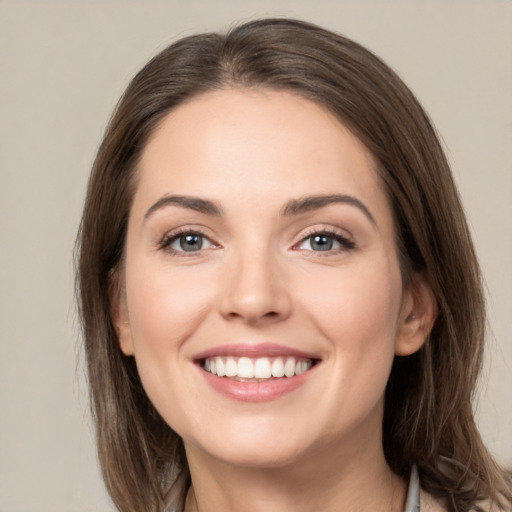 Joyful white young-adult female with long  brown hair and green eyes