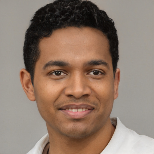 Joyful latino young-adult male with short  black hair and brown eyes