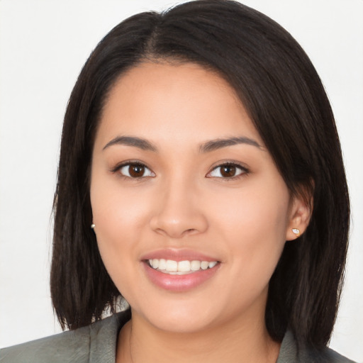 Joyful latino young-adult female with long  black hair and brown eyes