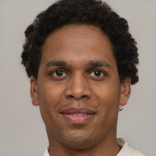 Joyful black young-adult male with short  brown hair and brown eyes