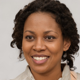 Joyful black adult female with medium  brown hair and brown eyes