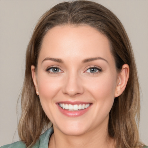 Joyful white young-adult female with medium  brown hair and grey eyes