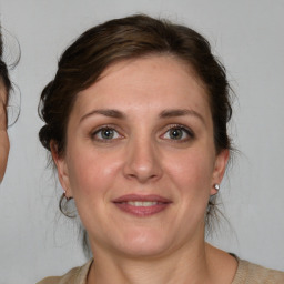 Joyful white adult female with medium  brown hair and grey eyes