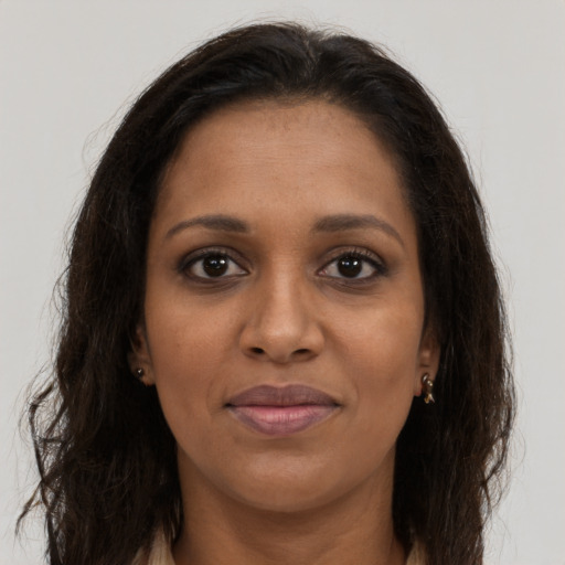 Joyful black young-adult female with long  brown hair and brown eyes