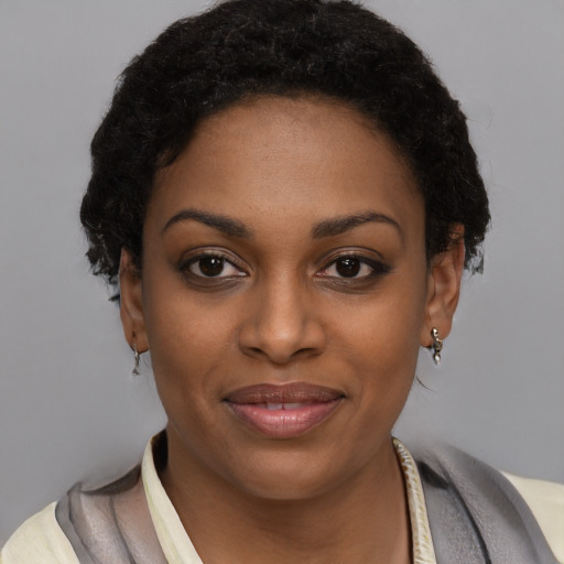Joyful black young-adult female with short  black hair and brown eyes