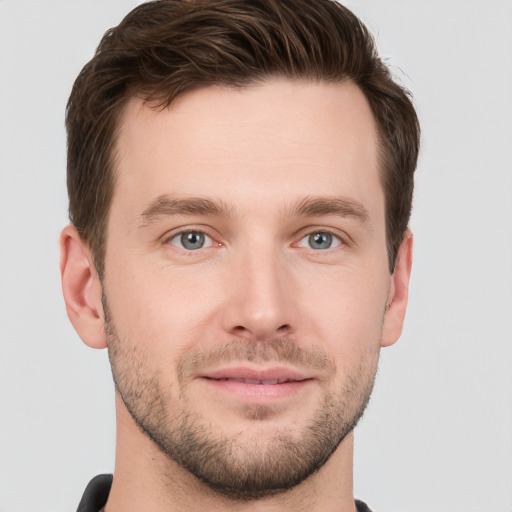 Joyful white young-adult male with short  brown hair and grey eyes