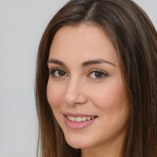 Joyful white young-adult female with long  brown hair and brown eyes