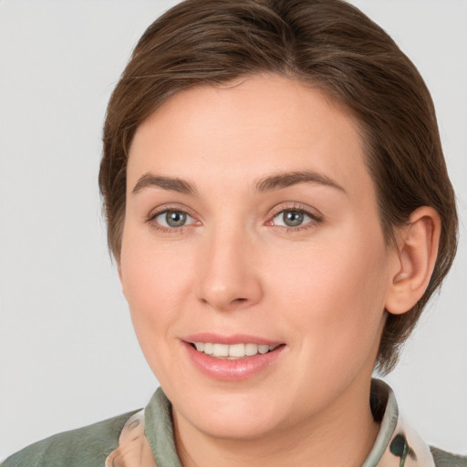 Joyful white young-adult female with medium  brown hair and grey eyes