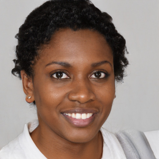Joyful black young-adult female with short  brown hair and brown eyes