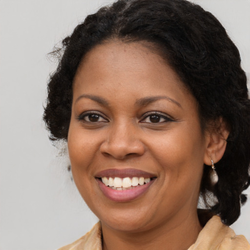 Joyful black young-adult female with long  brown hair and brown eyes