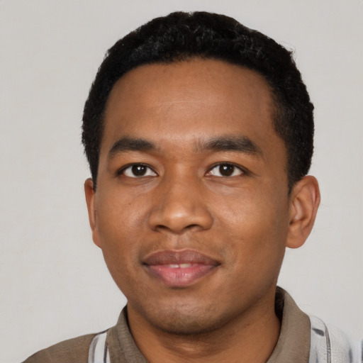 Joyful black young-adult male with short  black hair and brown eyes