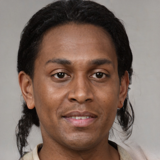 Joyful black young-adult male with short  brown hair and brown eyes