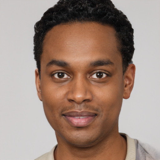 Joyful black young-adult male with short  black hair and brown eyes