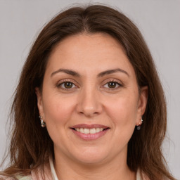 Joyful white adult female with long  brown hair and brown eyes