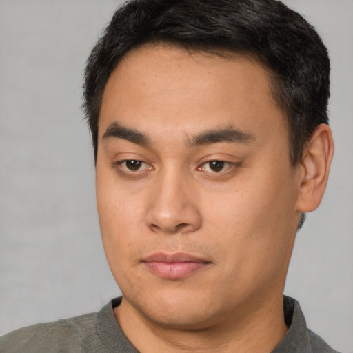 Joyful asian young-adult male with short  brown hair and brown eyes