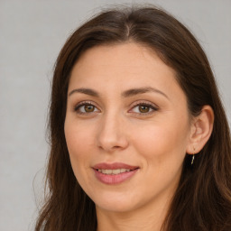 Joyful white adult female with long  brown hair and brown eyes