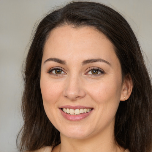 Joyful white young-adult female with long  brown hair and brown eyes