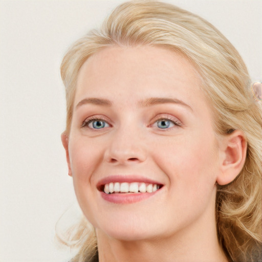 Joyful white young-adult female with long  brown hair and blue eyes