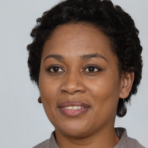 Joyful black adult female with short  black hair and brown eyes