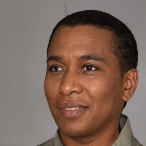 Joyful black adult male with short  black hair and brown eyes